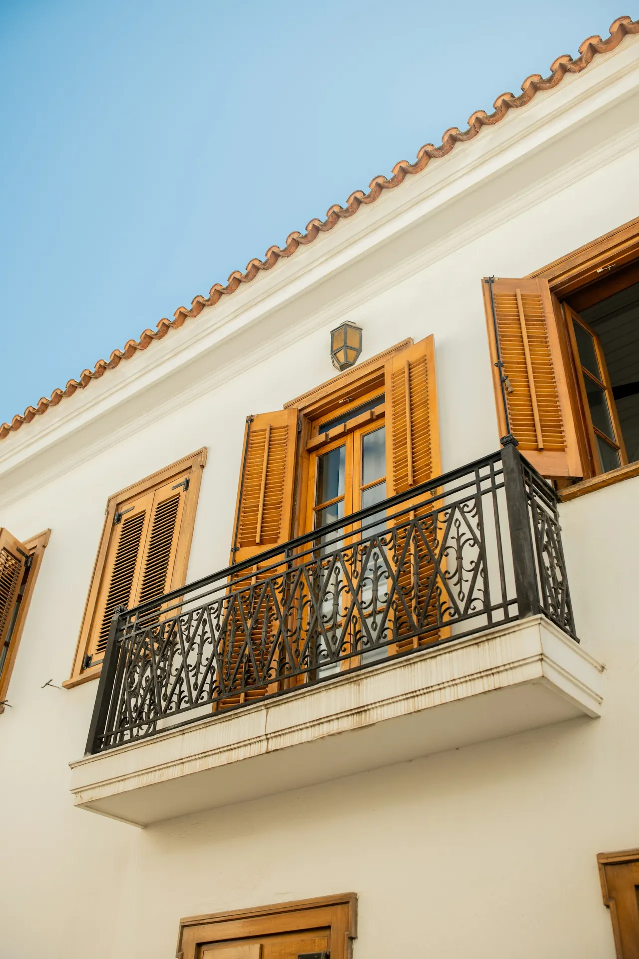 Balcón de forja con contraventanas de madera