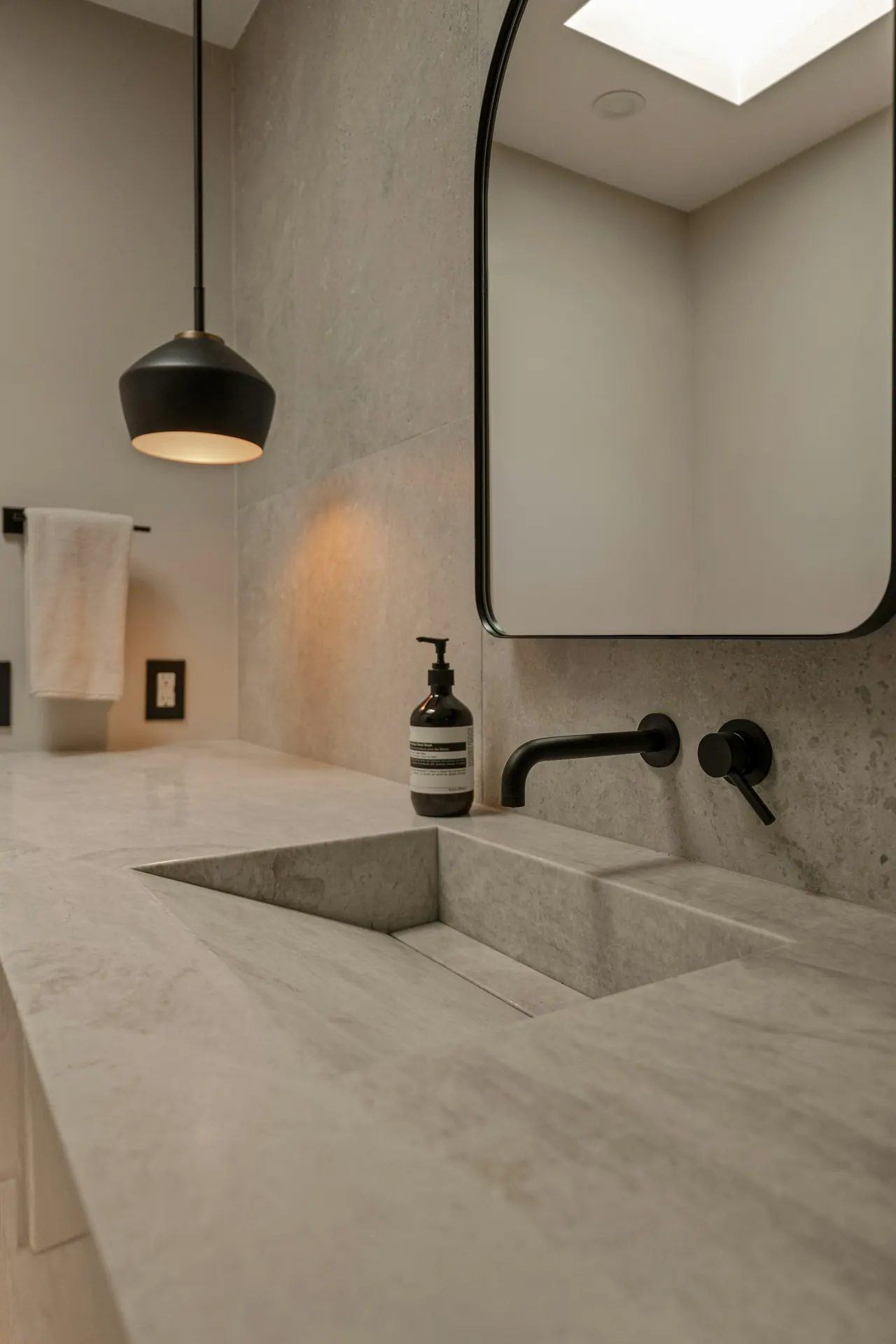 Baño de piedra con lavabo tallado y grifo negro