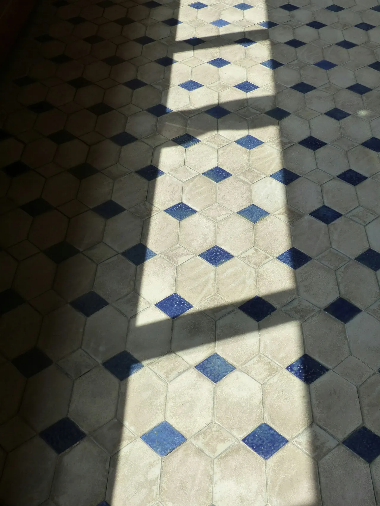 Suelo hidráulico blanco y azul con la luz de una ventana