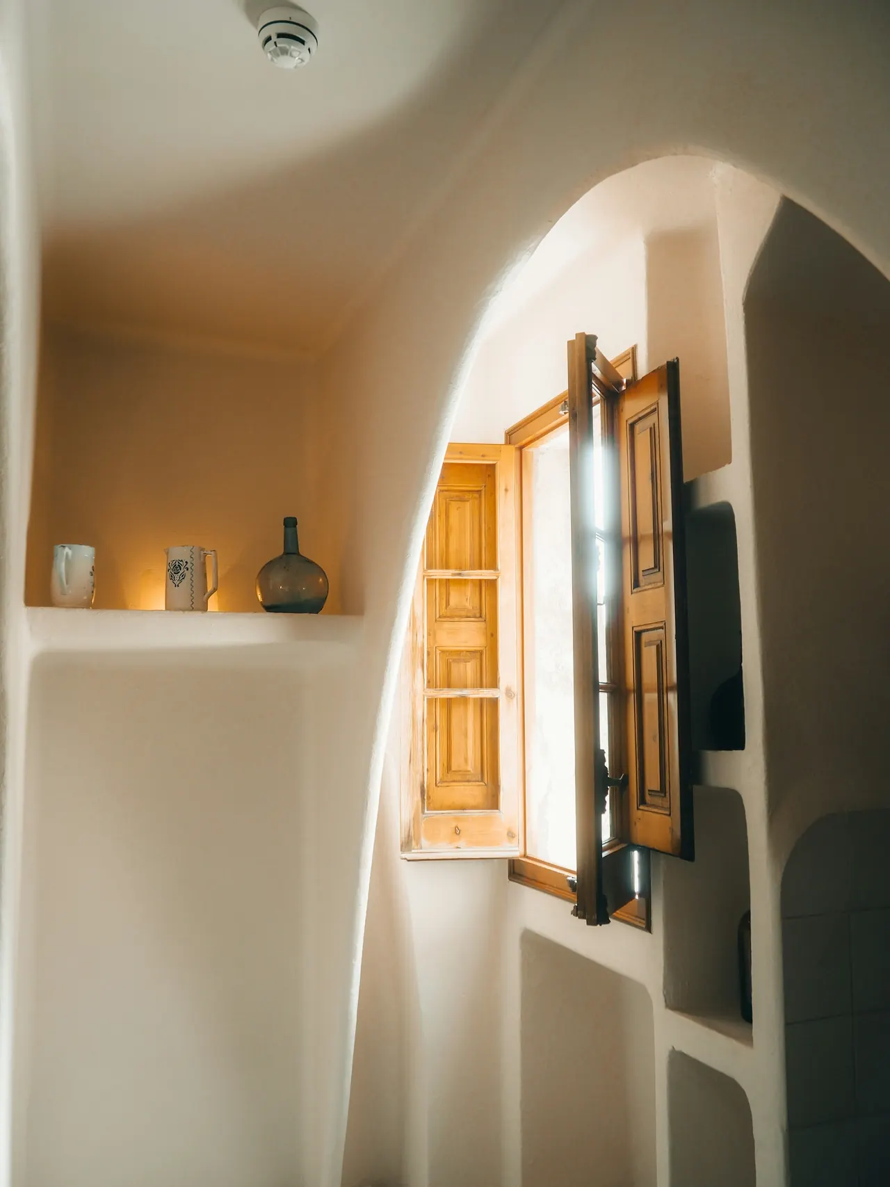 Ventana en arco con contraventana de madera abierta